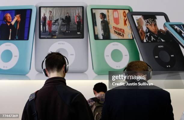 Customers at an Apple Store wear headphones as they listen to new Apple iPod nanos October 22, 2007 in San Francisco, California. Apple stock surged...