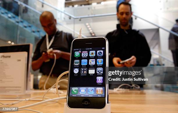 Customers at an Apple Store inspect the Apple iPhone October 22, 2007 in San Francisco, California. Apple stock surged $3.94 to close at a record...