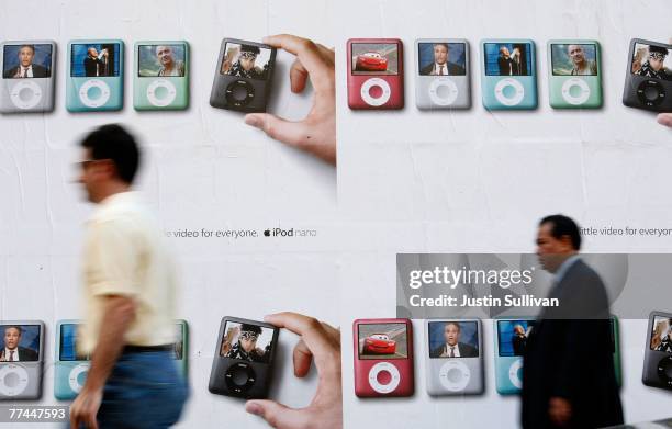 Pedestrians walks by a billboard featuring the new Apple iPod nano October 22, 2007 in San Francisco, California. Apple stock surged $3.94 to close...