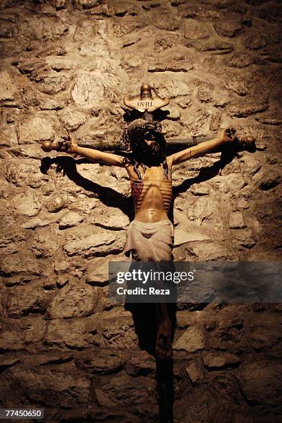 Detail of a crucifix on the stone wall of a church August, 2007 in Villefranche de Conflent, France.