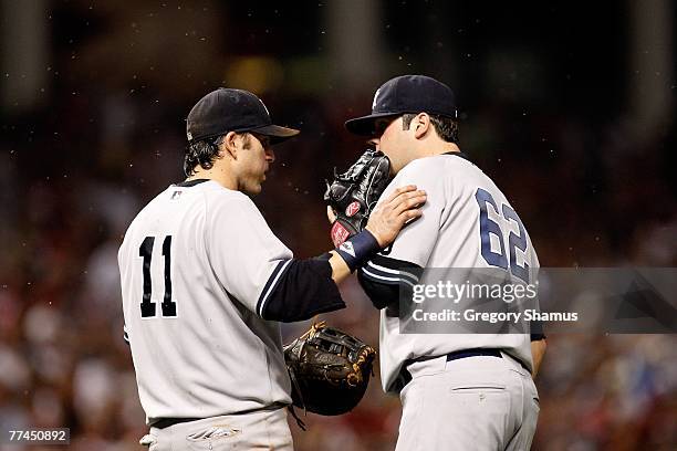 Doug Mientkiewicz and Joba Chamberlain of the New York Yankees talk on the mound as gnats swarm around them against the Cleveland Indians during Game...