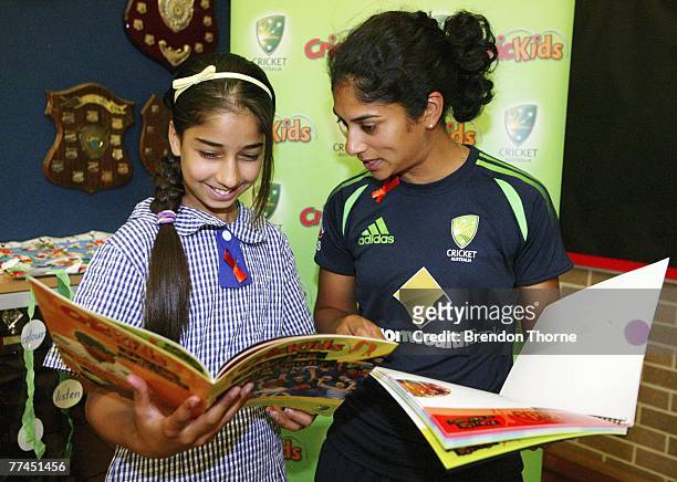 Lisa Sthalekar of the Australian Southern Stars reads a Harmony Handbook with a student during the launch of Cricket Australia's "Playing In Harmony"...