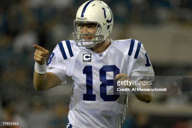 Quarterback Peyton Manning of the Indianapolis Colts points to the bench after tossing a touchdown pass against the Jacksonville Jaguars at the...