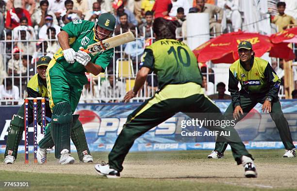 Pakistani cricketers Shahid Afridi and Younis Khan watch South African captain Graeme Smith playing a shot during the third day-night international...