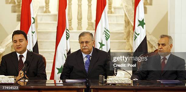 Turkish Foreign Minister Ali Babacan speaks next to Iraq's President Jalal Talabani , and Iraq's Vice President Tareq al-Hashemi during a news...