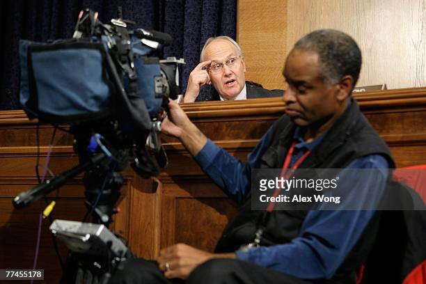 Sen. Larry Craig speaks as a TV cameraman points his camera at him during a hearing on the impacts of global warming on public health before the...