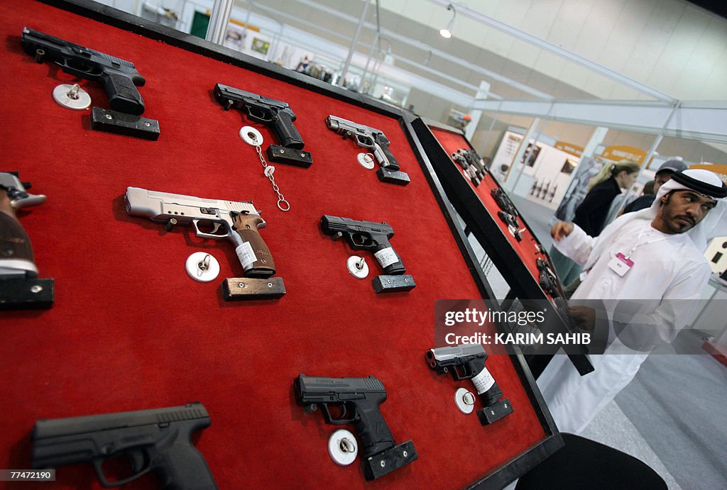An Emirati exhibitor stands by a display