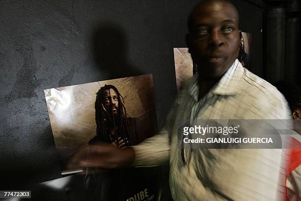 Staff from the Bassline music club in downtown Johannesburg hangs 24 October 2007 posters of South African reggae musician Lucky Dube, that was shot...