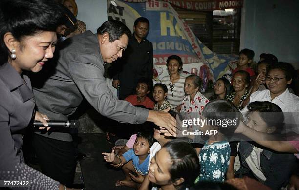 Indonesian President Susilo Bambang Yudhoyono and First Lady Kristiani Yudhoyono meet with residents at refugee camp in the village of Segaren, below...