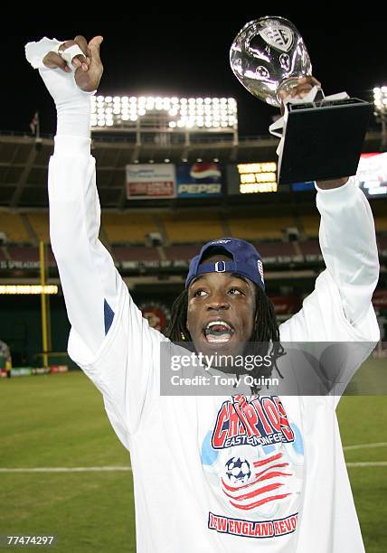 Revolution's Shalrie Joseph proudly carries the Eastern championship trophy after Revolution wins the MLS Eastern Champsionship at RFK Stadium in...