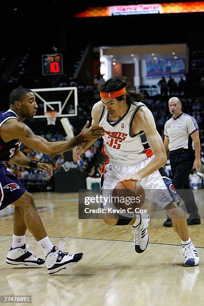 Adam Morrison of the Charlotte Bobcats drives the ball around Acie Law of the Atlanta Hawks during the game at Charlotte Bobcats Arena on October 18,...