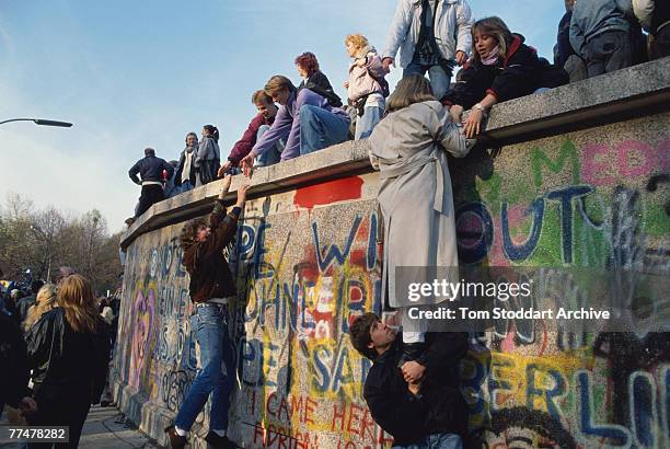 Crowds bear witness to the Fall of the Berlin Wall, 10th November 1989. They are on a section of the wall near the Brandenburg Gate - a high profile...