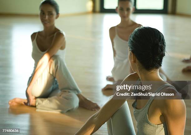 exercise class doing spinal twist - spinal twist stock pictures, royalty-free photos & images