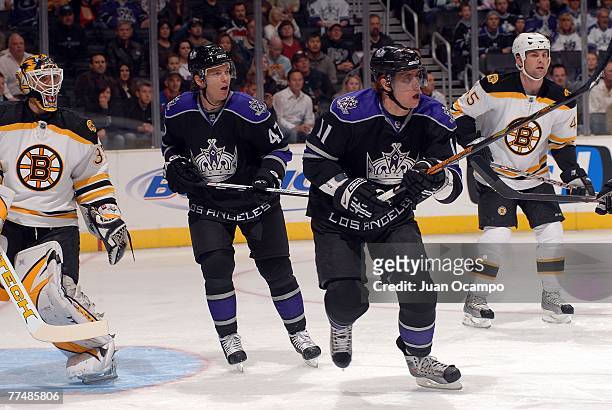 Anze Kopitar and Ladislac Nagy of the Los Angeles Kings watch the puck in play against goaltender Manny Fernandez and Mark Stuart of the Boston...