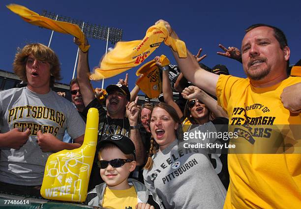 Young Oakland Raiders fan is surrounded by Pittsburgh Steelers fans waving Terrible Towels during game at McAfee Coliseum in Oakland, Calif. On...