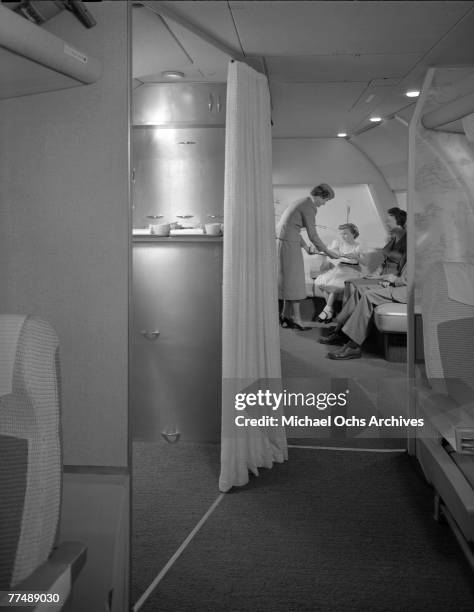 S: An air hostess serves passengers in the observation area of a Transocean Air lines Boeing 377 Stratocruiser in the mid 1950's. Transocean Air...