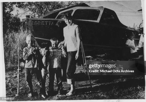 Country singer Loretta Lynn poses for a portrait with 3 little boys in circa 1950 in Butcher Holler, Kentucky.