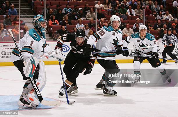 Goaltender Thomas Greiss of the San Jose Sharks defends his net as Rob Niedermayer of the Anaheim Ducks skates through the slot behind defenseman...