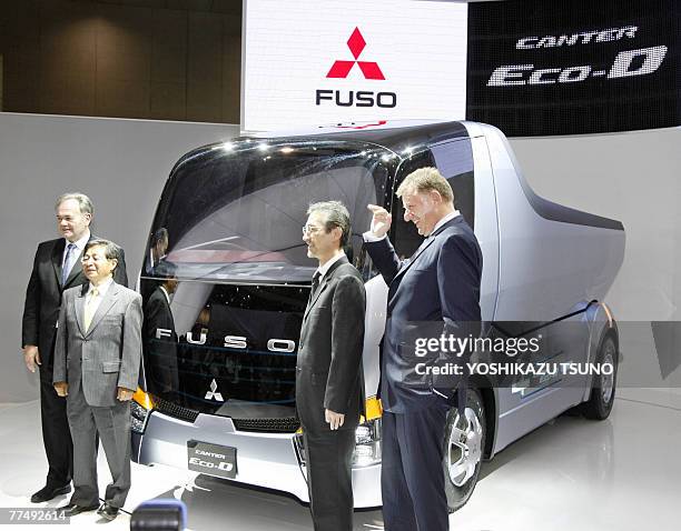 German auto giant Daimler AG board member Andreas Renschler and Mitsubishi Fuso Truck and Bus president Harald Boelstler introduce the hybrid...