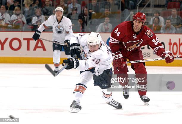 Center Shawn Horcoff of the Edmonton Oilers shoots as center Daniel Winnik of the Phoenix Coyotes pursues on October 18, 2007 at Jobing.com Arena in...