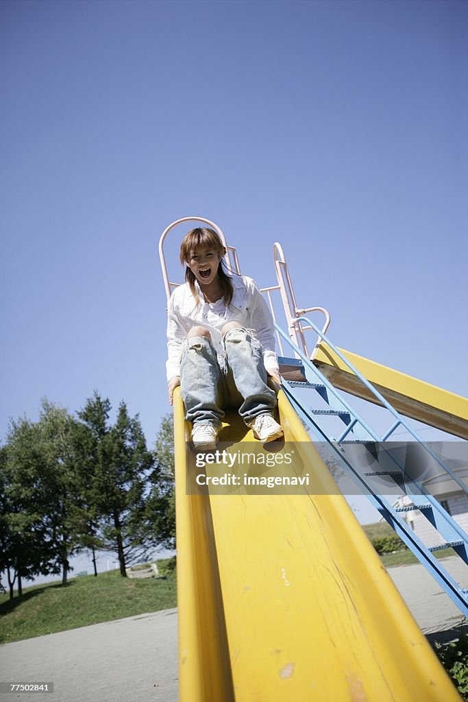 Young woman playing on a slide