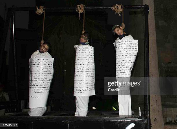 Three executed Syrian men hang from the gallows with signs detailing their crimes wrapped around their bodies in the centre of the northern town of...