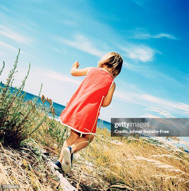 girl on her way to the beach oland sweden. - red dress photos et images de collection