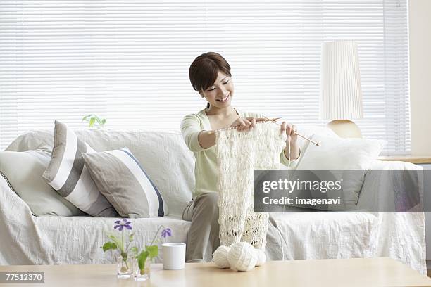 woman on sofa knitting - 若い女性一人 ストックフォトと画像