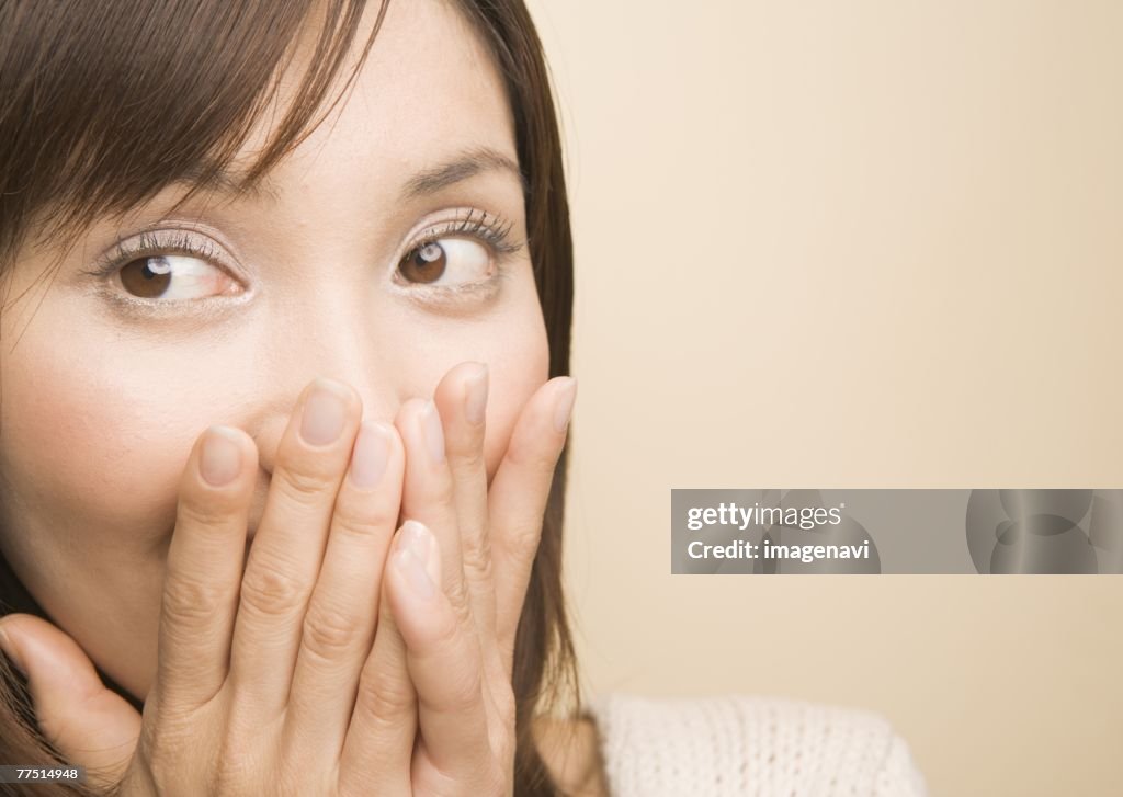 Woman covering mouth with hands