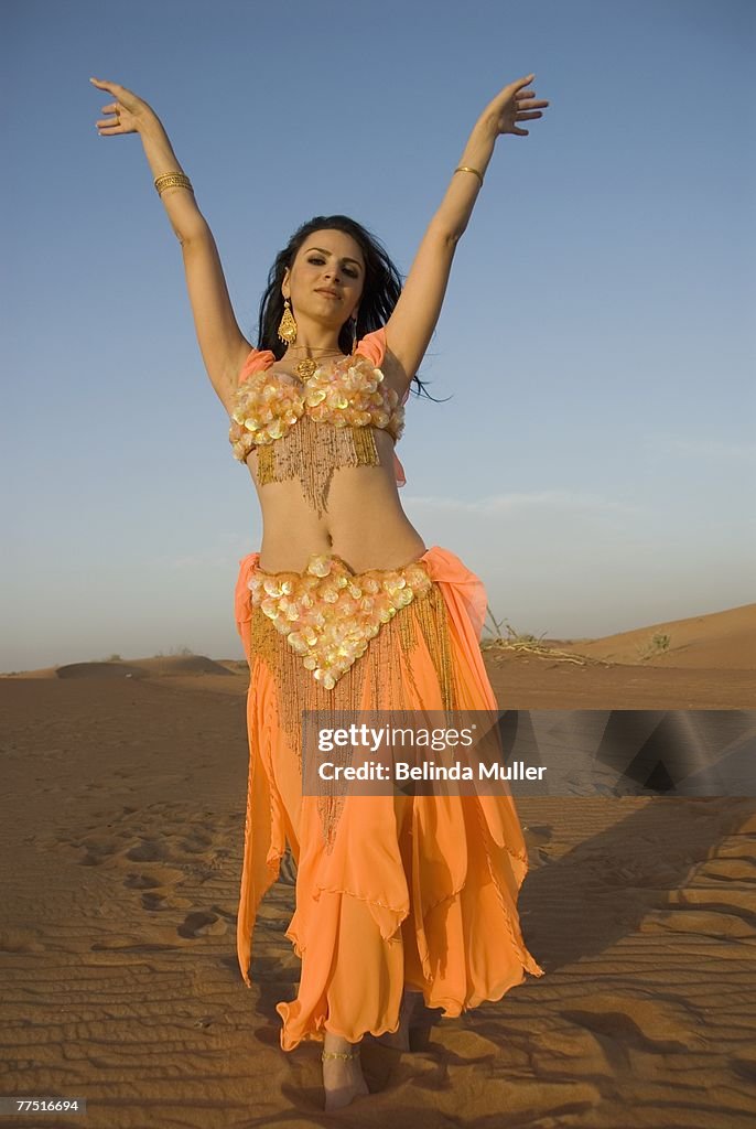 Young Belly Dancer Dancing in the Desert. Hatt Desert, Dubai, United Arab Emirates