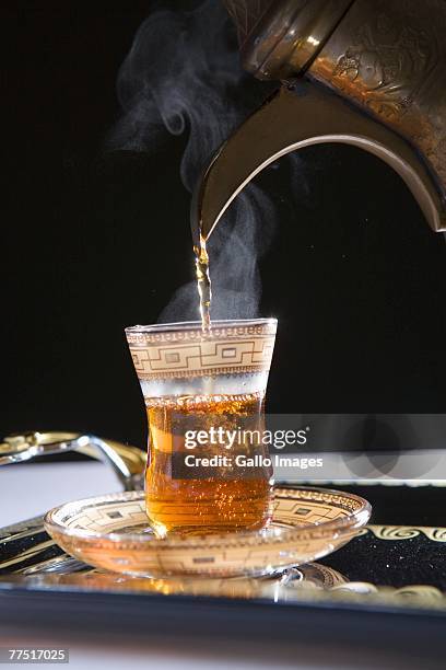 pouring steamy hot tea with dallah into cup. dubai, united arab emirates - coffee pot stock pictures, royalty-free photos & images