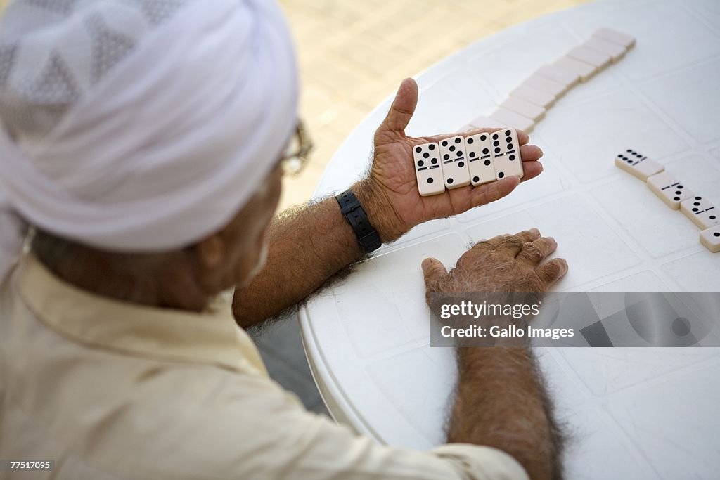 Arab man playing dominoes, high angle view. United Arab Emirates