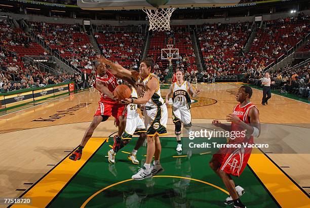 Rafer Alston of the Houston Rockets tries to pass the ball to teammate Tracy McGrady of the Rockets under pressure from Wally Szczerbiak of the...