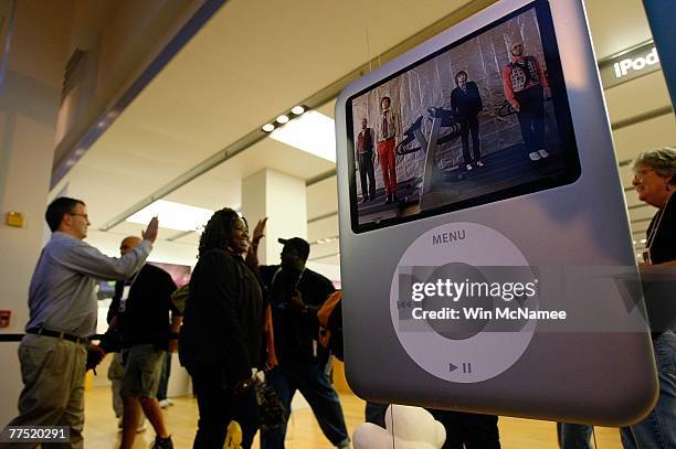 Customers who had lined up to purchase the new Apple operating system known as Leopard are greeted with a high-fives from fellow shoppers on entering...