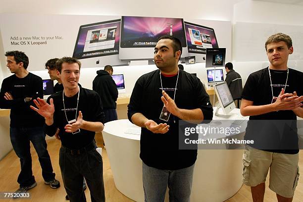 Store employees applaud customers waiting to purchase the new Apple computer operating system known as Leopard at an Apple store October 26, 2007 in...