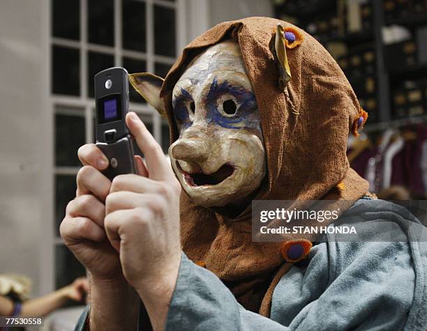 Paul Gleason in his ghoulish mask takes a cell phone photograph of another masked actor backstage before the "Halloween Extravaganza & Procession of...