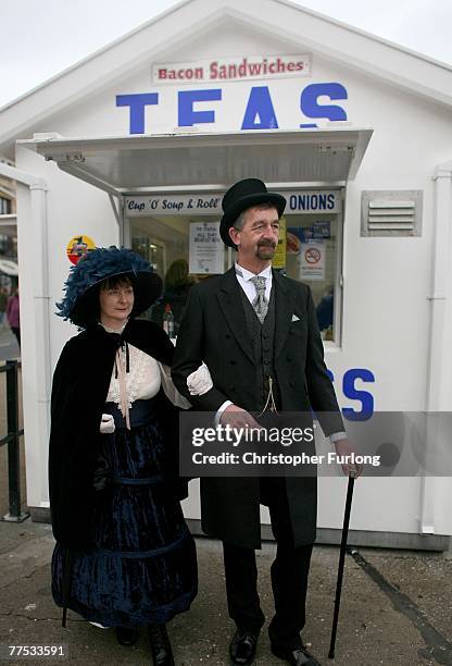 Couple who are fans of Victoriana walk the promenade during Whitby Gothic Weekend on October 26 Whitby, England. Whitby Gothic Weekend which started...