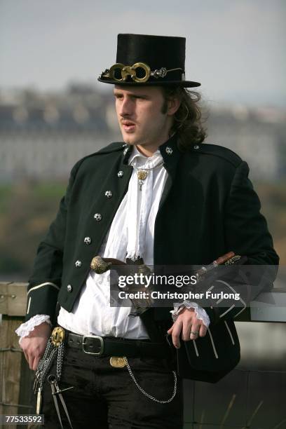 Goth dressed in a Victorian naval uniform watches people promenade during Whitby Gothic Weekend on October 27 Whitby, England. Whitby Gothic Weekend...