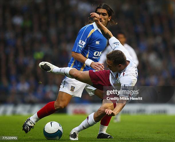 Craig Bellamy of West Ham United is challenged by Pedro Mendes of Portsmouth during the Barclays Premier League match between Portsmouth and West Ham...