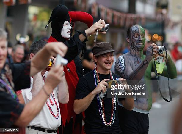 People take photographs of others participating in the Fantasy Fest Masquerade March October 27, 2007 in Key West, Florida. The 10-day costuming and...