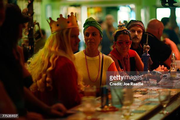Revelers wear their costumes as they sit at a bar during the Fantasy Fest Masquerade March October 27, 2007 in Key West, Florida. The ten day...