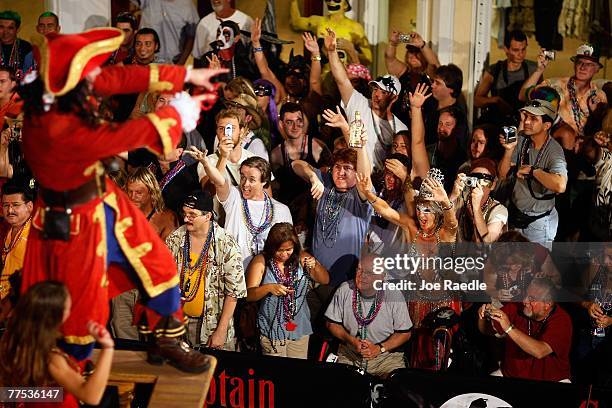 People react to a float passing through the streets as they participating in the Fantasy Fest Masquerade parade October 27, 2007 in Key West,...