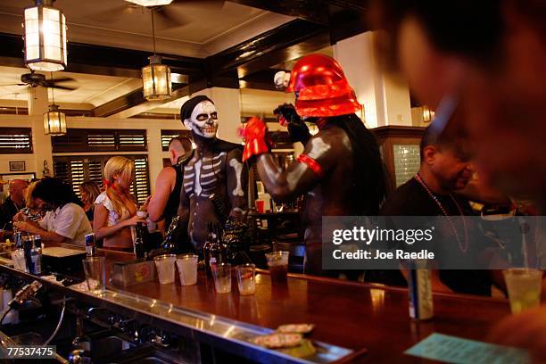 Robbie Chambers waits for his beer at a bar during Fantasy Fest October 27, 2007 in Key West, Florida. The 10-day costuming and masking festival ends...