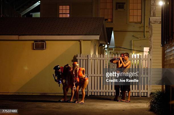 Visitors to the Fantasy Fest parade take photographs of women as they enjoy themselves October 27, 2007 in Key West, Florida. The 10-day costuming...