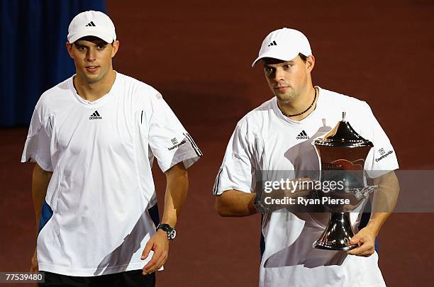 Mike Bryan and Bob Bryan of the USA leave the court with the trophy after winning the Doubles Final against Mark Knowles of the Bahamas and James...