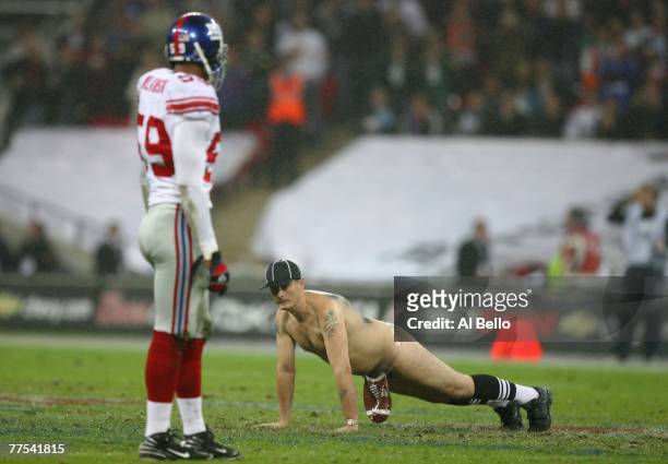 'Serial streaker' Mark Roberts performs 'push-ups' on the field of play during the NFL Bridgestone International Series match between New York Giants...
