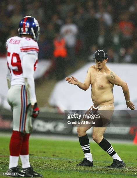 'Serial streaker' Mark Roberts dances on the field of play during the NFL Bridgestone International Series match between New York Giants and Miami...