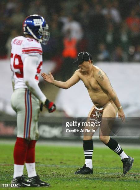 'Serial streaker' Mark Roberts dances on the field of play during the NFL Bridgestone International Series match between New York Giants and Miami...