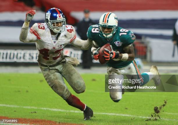 Ted Ginn Jr. #19 of the Dolphins makes a touchdown reception past Michael Johnson of the Giants during the NFL Bridgestone International Series match...
