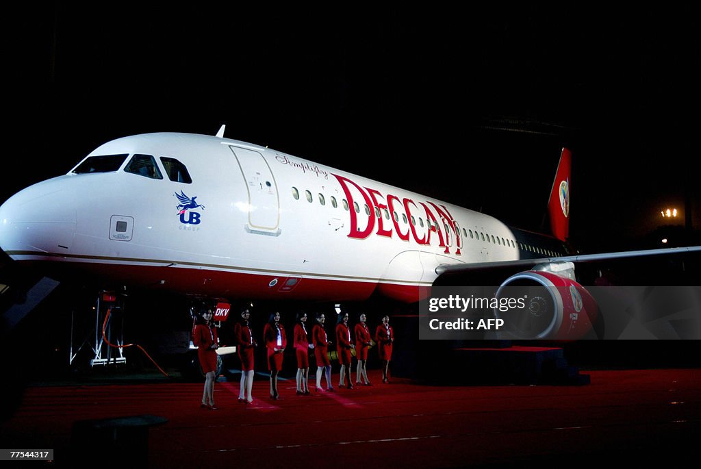 Indian air hostesses pose alongside a De